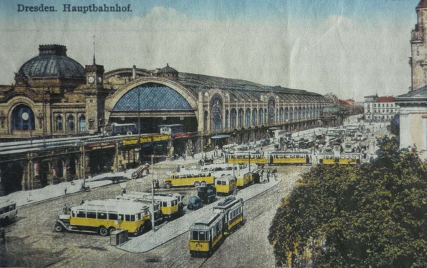 Schwarz-weiß-Postkarte des Dresdner Hauptbahnhof Bahnhofs in Deutschland, zeigt eine belebte Straßen Szene mit Fahrzeugen, Fußgängern, Bäumen, Gebäuden und einem bewölkten Himmel.