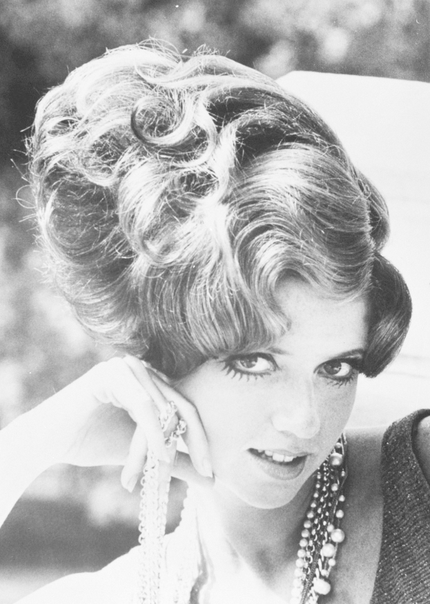 Schwarzes und weißes Foto von Prinzessin Diana in einem Kleid mit verzierten Accessoires, Hintergrund unscharf.