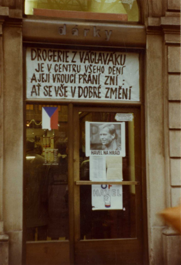 Ein altes Foto einer Glastür mit einem Schild, einem Plakat einer Person und einigen angeklebten Papieren.