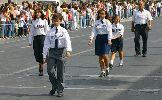 Menschen auf einer Straße bei einem Ereignis, mit Abzeichen auf der Kleidung, umgeben von einer großen Menge.