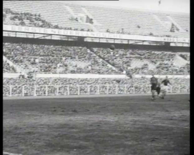 Schwarzes und weißes Foto eines Fußballspiels in einem Stadion während des niederländischen Fußball-Meisterschaftsfinals 1961-1962, das Spieler auf dem Feld und Zuschauer in den Rängen zeigt.