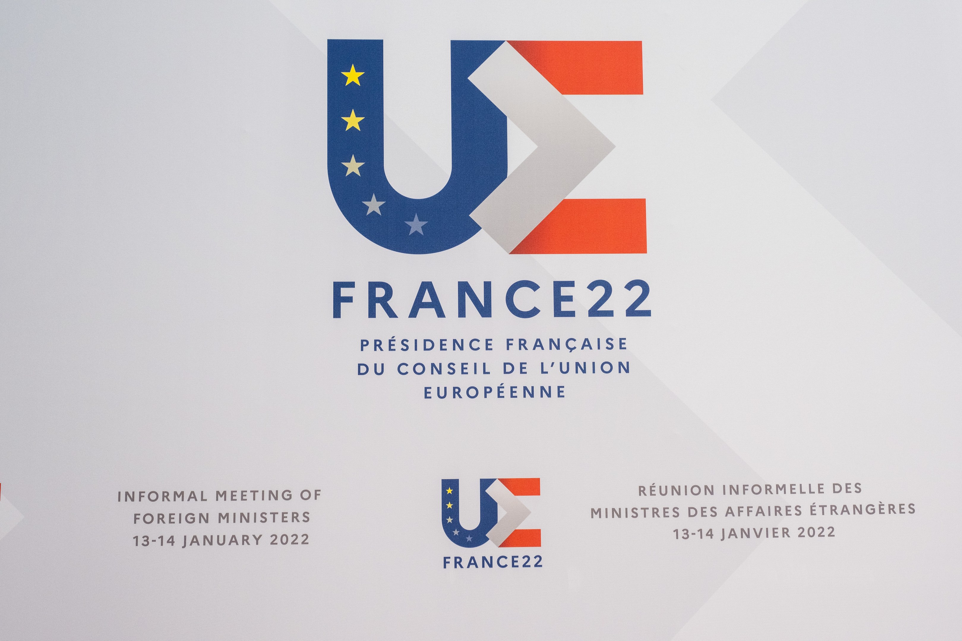 Plakat für die "Frankreich 22 - Informelle Tagung der Außenminister" mit dem Logo der Europäischen Union, einem blauen Kreis, weißer Umrandung und einem zentralen weißen Stern.