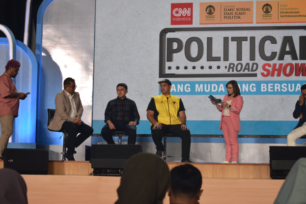 Eine Gruppe von Menschen auf einer Bühne mit einigen stehenden auf einem Podium und einem Schild im Hintergrund mit der Aufschrift "Cnn Political Road Show."